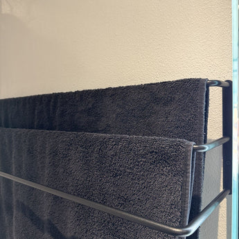 sort håndklædestang som er væghængt