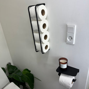 Holder til toiletpapir med hylde, sort i baggrunden en toiletpapirsholder i sort
