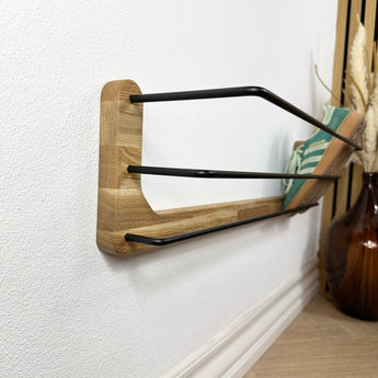 Væghængt Hermann skohylde i træ og sort pulverlakeret stål.